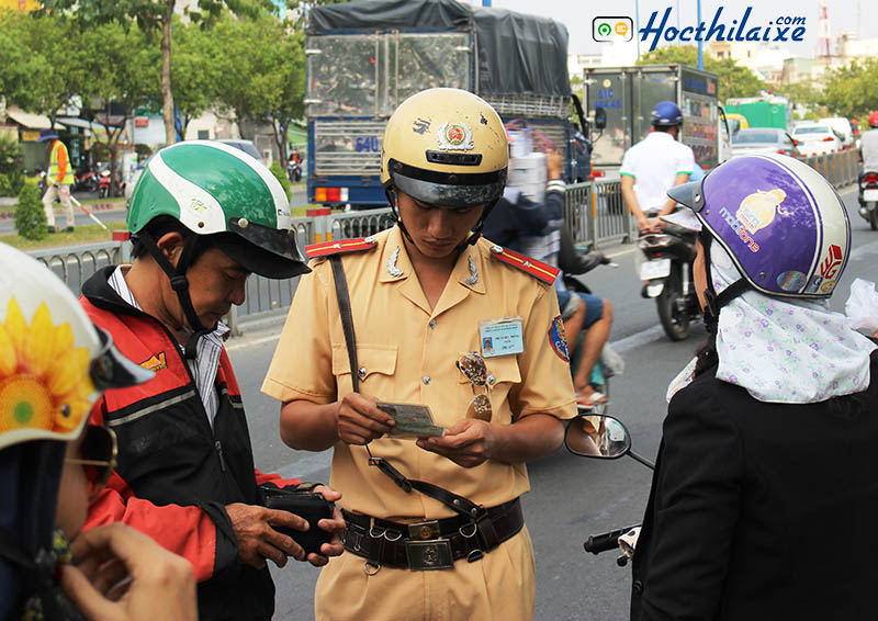 CSGT kiểm tra thông tin giấy đăng kí xe của người tham gia giao thông